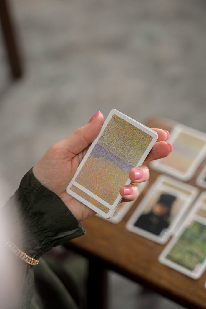 A person holding a tarot card indoors with a soft focus background, ideal for mystical content.